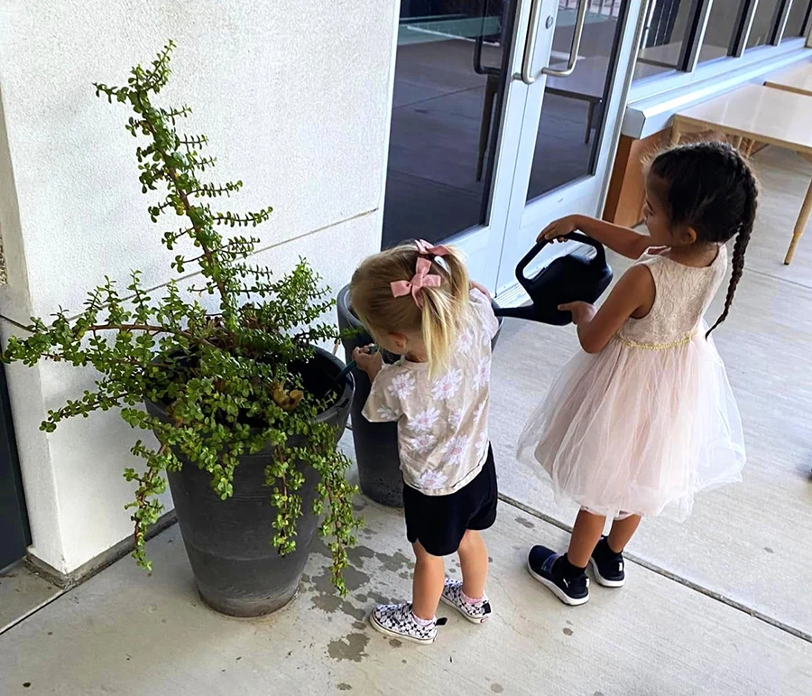 Children watering plants on the patio